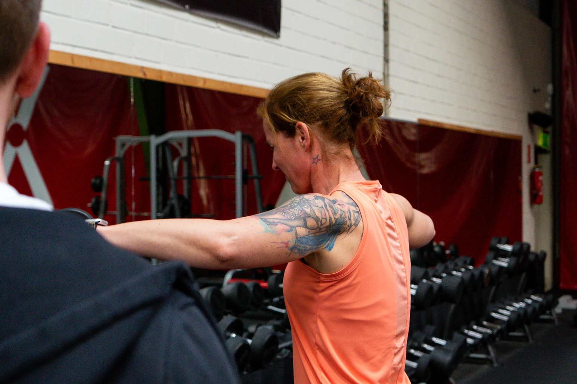 Klientin beim Seitheben-Training mit Daniel Probst im Fitnessstudio